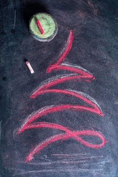 Graphical representation of a Christmas tree drawn with chalk on blackboard