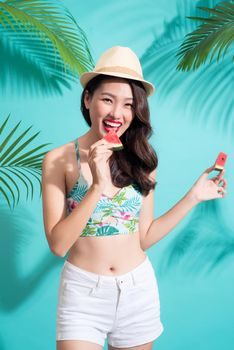 Summer fashion girl in summer outfit eating watermelon.