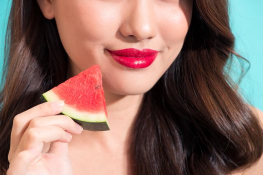 Closeup of the beautiful girl with red lips eating watermelon.