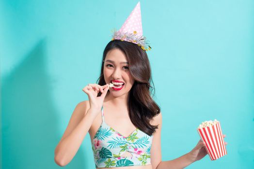 Summer fashion girl in summer outfit eating popcorn.