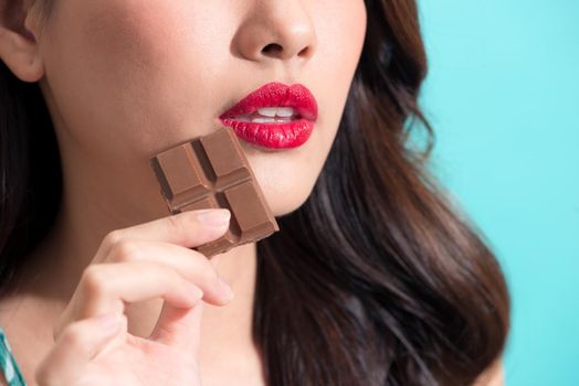 Closeup of the beautiful girl eating chocolate