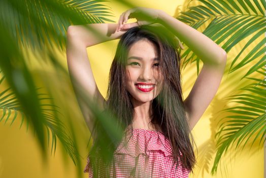 Fashion pretty asian woman posing and smiling over bright summer background