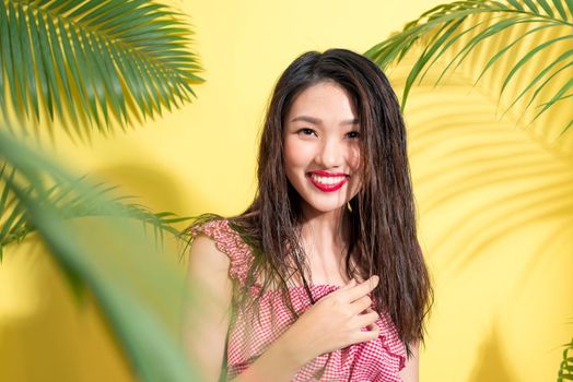 Summer fashion girl standing and smiling over vibrant yellow background