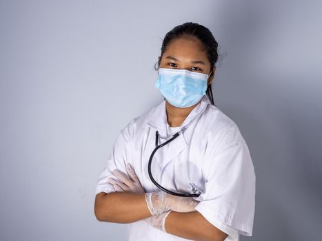 Studio portrait of a female doctor wearing a mask standing on a white background There was a slight light on his face.