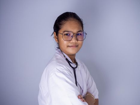 Portrait of a female doctor wearing glasses Standing with arms crossed on a white background.