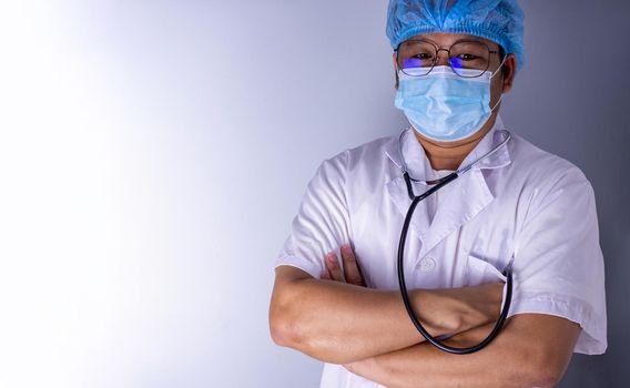 Portrait of a doctor wearing a mask and wearing a hat Standing pose with arms crossed. Medical concept and treatment.