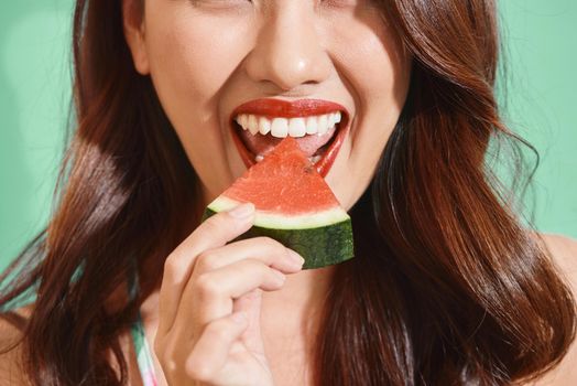 Pretty Asian women eating a slice of watermelon in summer
