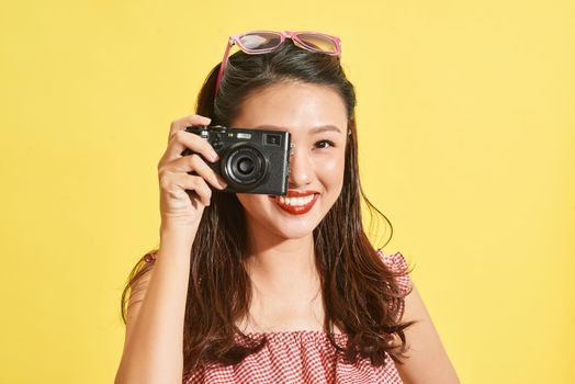 A young Asian woman photographer holding film camera