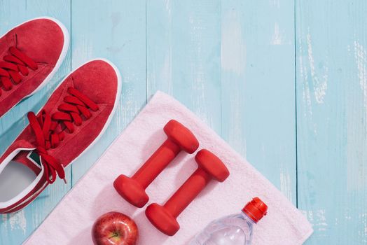 fitness concept with dumbbells and red apple - sport and leisure