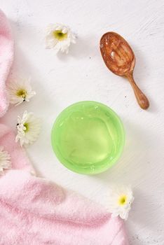 spa setting with cosmetic gel, leaves on white table background