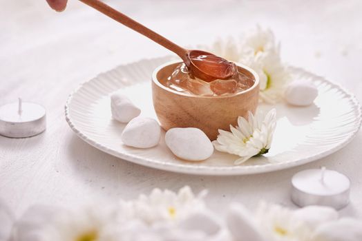 Aloe vera gel on a bowl, with chrysanthemum and candle in stone table