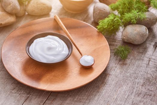 Preparing handmade hydrating natural gel and anti-aging cosmetic from extract of aloe vera leaves with pebbles and wooden background for zen beauty, top view