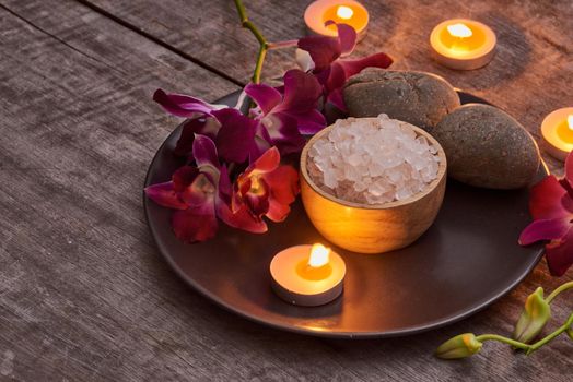 bath salt at bamboo bowl and orchids flowers on dark wood