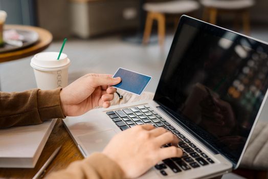 Businessman hand holding credit card and use laptop 