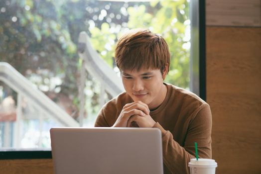 Modern business man connecting to wireless on his laptop computer during coffee break, male freelancer drink tea while working on notebook in loft studio, university student working at cafe or library