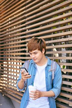 Stylish young man standing in the street and talking on the phone