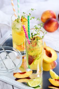 Peach summer cocktail. Refreshing organic non-alcoholic drink, lemonade with ripe nectarine, thyme and lime  