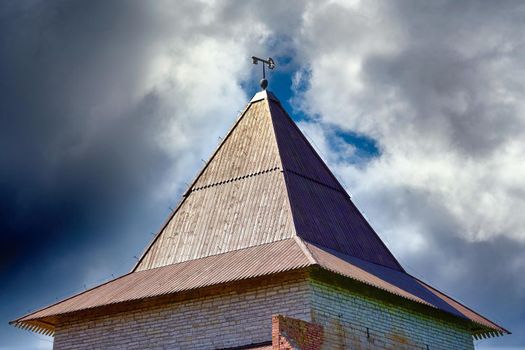 Key symbol of the city on the roof of the fortress tower against the blue sky