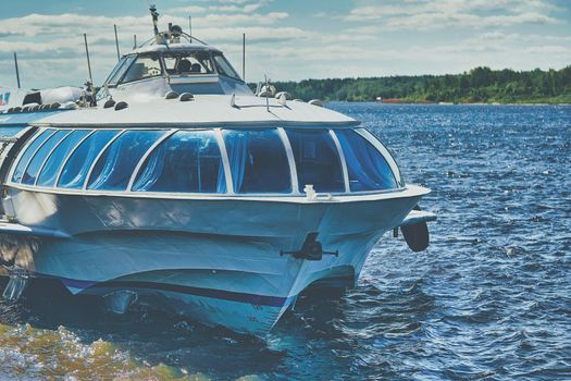 A hydrofoil ship sails along the river. River ship Meteor.