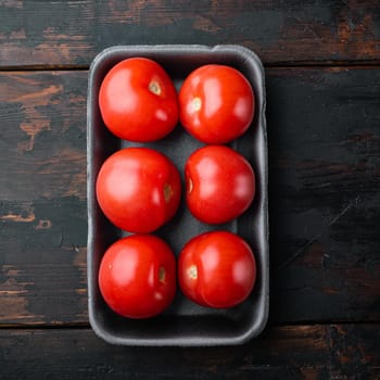 Fresh red organic tomatoes, on dark wooden background