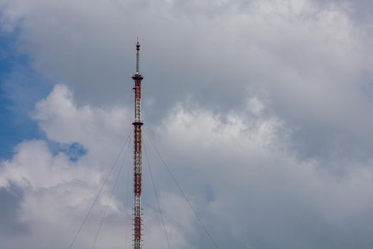 tall metal frame television tower on cloudy sky daylight background.