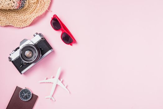 Top view flat lay mockup of retro camera films, airplane, hat, sunglasses, starfish beach traveler accessories on pink background with copy space, Business trip, and vacation summer travel concept