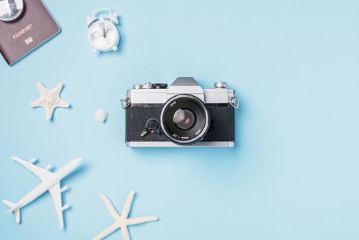 Flat lay top view mockup retro camera films, airplane, passport, starfish, shells traveler tropical accessories on a blue background with copy space, Vacation summer travel and business trip concept