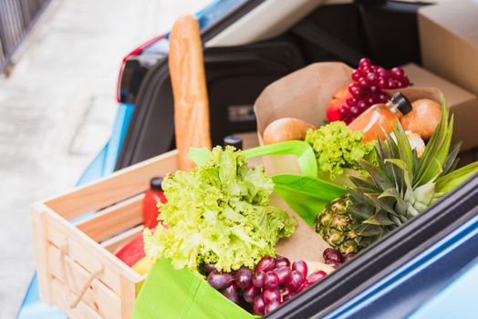 Grocery service giving fresh vegetables and fruits and food in green cloth bag and wooden basket on the back car ready delivery to send woman customer