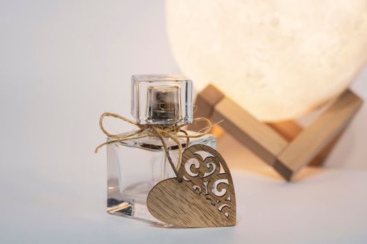 A bottle of women's eau de toilette or perfume with a heart, a gift for a beloved woman.
