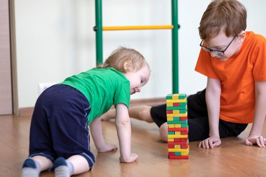 Children play in the playroom in a board game to gather the tower. Two brothers.