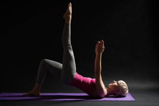 Woman exercising pilates. One legged shoulder bridge exercise.