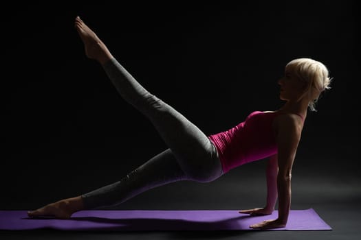 Woman exercising pilates. Leg pull back exercise.