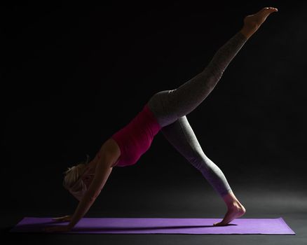 Woman exercising pilates. Single leg high plank pike exercise.