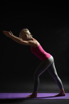 Woman exercising pilates. Variation of standing leg stretch exercise.