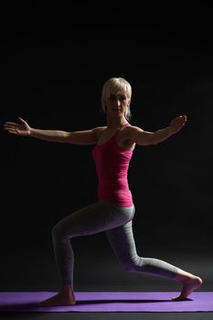 Woman exercising pilates. Standing lunge with arm rotation.