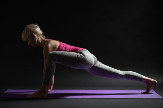 Woman exercising pilates. Low lunge yoga stretch exercise.