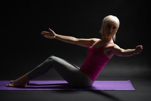 Woman exercising pilates. Exercise for body health.
