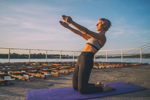 Woman exercising pilates on sunny day.