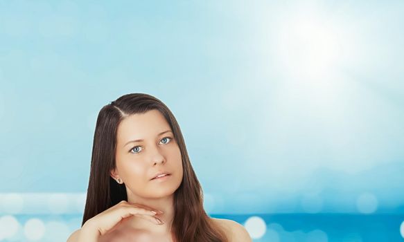 Skincare and sun protection in summer. Portrait of a beautiful young suntanned woman, blue sea and sky on background, beauty, wellness and travel concept.