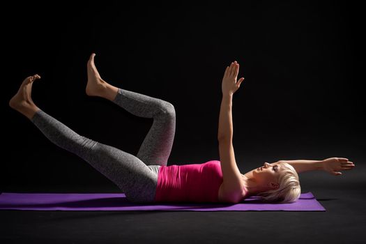 Woman exercising pilates. Exercise for body health.