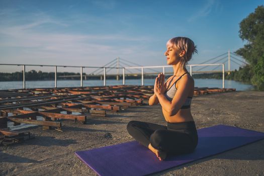 Woman practicing yoga on sunny day. Padmasana, Lotus pose.