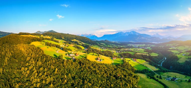 Green meadows, alpine houses and mountain peaks, Salzburger area, Austria.