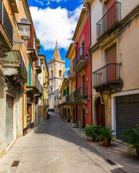 Picturesque street with the Duomo in the background in Novara di Sicilia, Sicily, Italy. Amazing cityscape of Novara di Sicilia town. Mountain village Novara di Sicilia, Sicily, Italy.