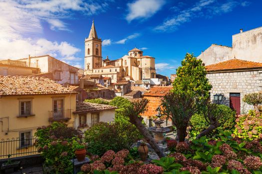 Picturesque street with the Duomo in the background in Novara di Sicilia, Sicily, Italy. Amazing cityscape of Novara di Sicilia town. Mountain village Novara di Sicilia, Sicily, Italy.
