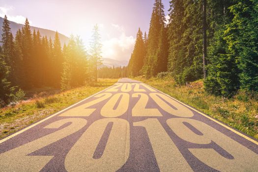 Empty asphalt road and New year 2019, 2020, 2021 concept. Driving on an empty road in the mountains to upcoming 2019, 2020, 2021 and leaving behind old years. Concept for success and passing time.