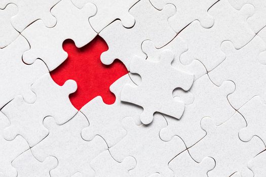 Unfinished white jigsaw puzzle pieces. Fill in pieces of the jigsaw puzzle. Complete the jigsaw puzzle with the missing pieces. Fragment of a folded white jigsaw puzzle.