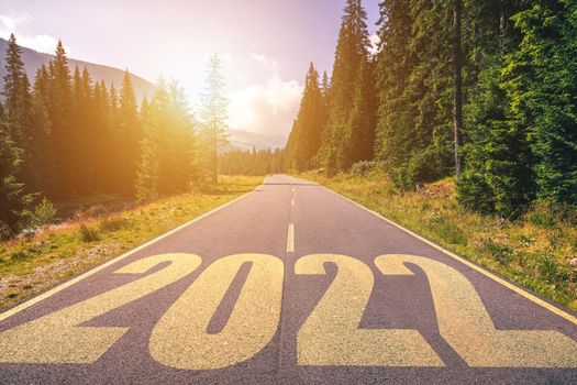 Empty asphalt road and New year 2022 concept. Driving on an empty road in the mountains to upcoming 2022. Concept for success and passing time.