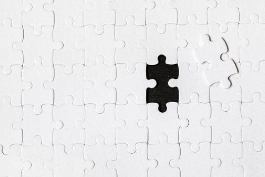 White jigsaw puzzle. White puzzle pieces on color background. Unfinished white jigsaw puzzle pieces on color background. 