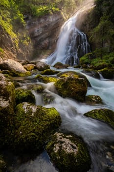 Gollinger Waterfall in Golling an der Salzach near Salzburg, Austria. Gollinger Wasserfall with mossy rocks and green trees, Golling, Salzburger Land, Austria.