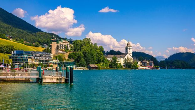 Embankment promenade at the Wolfgangsee lake in Austria. Wolfgangsee is one of the best known lakes in the Salzkammergut resort region of Austria. Village St Wolfgang on the lake Wolfgangsee, Austria